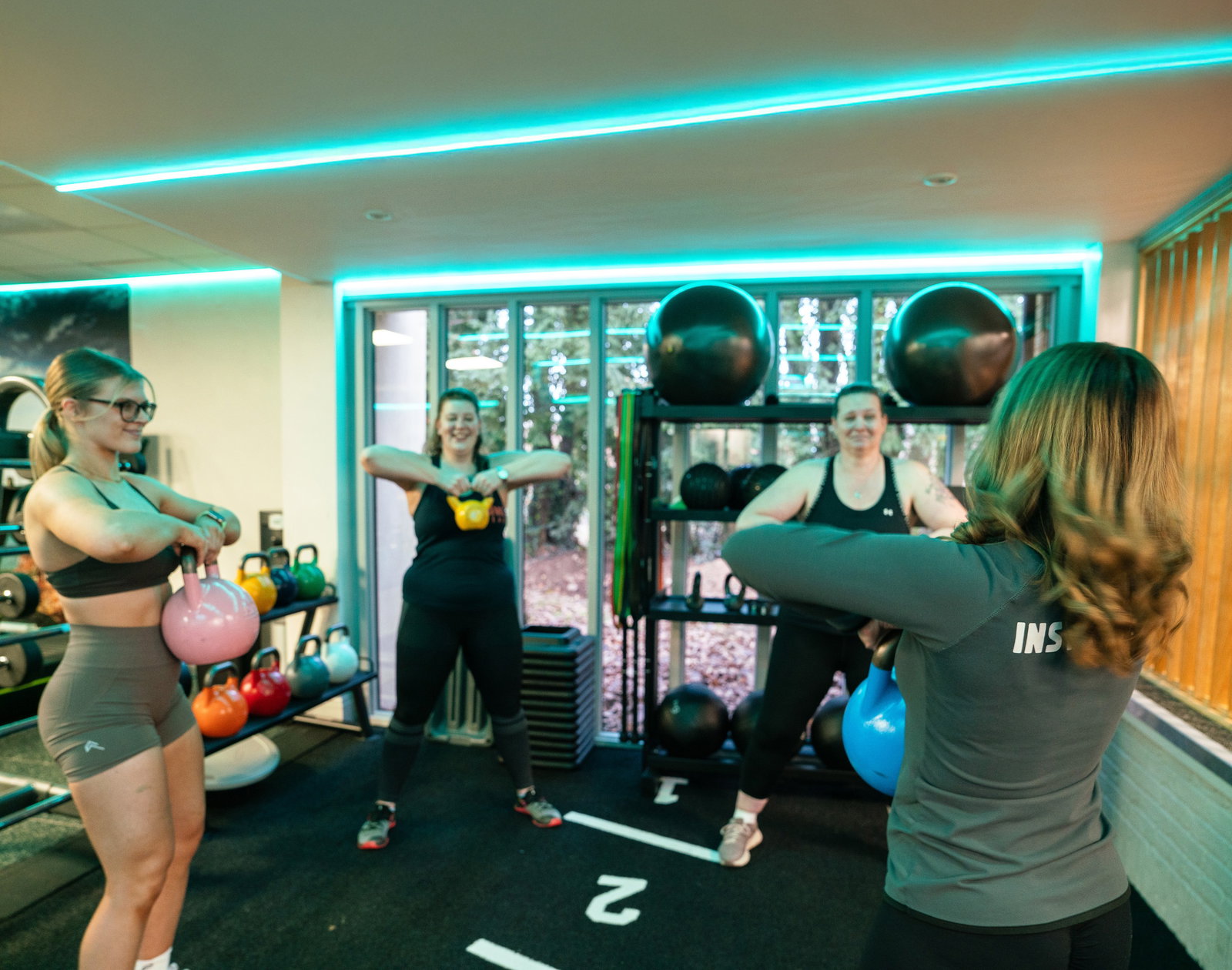 A trainer supporting someone during a gym session