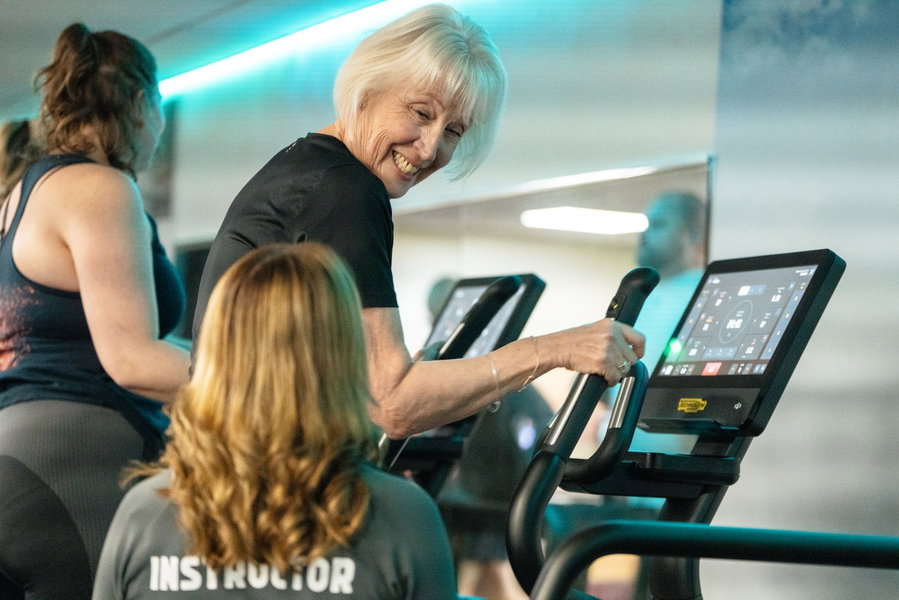 A personal trainer supporting a gym member