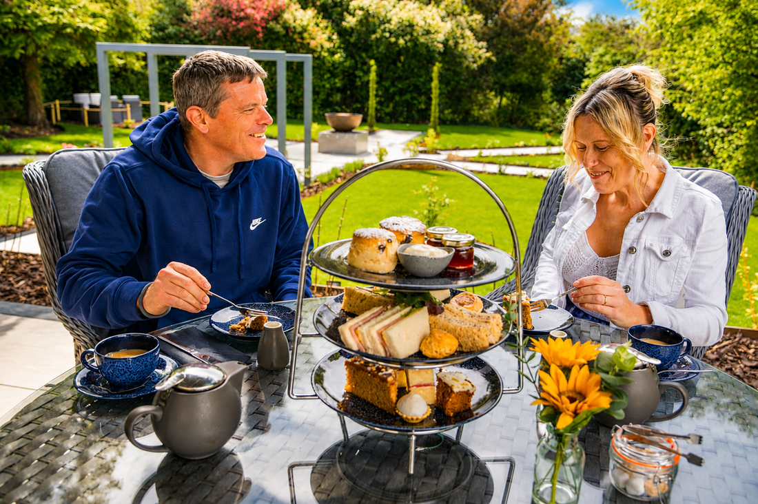 A man and woman enjoying an afternoon tea outdoors in the Riverhills spa garden