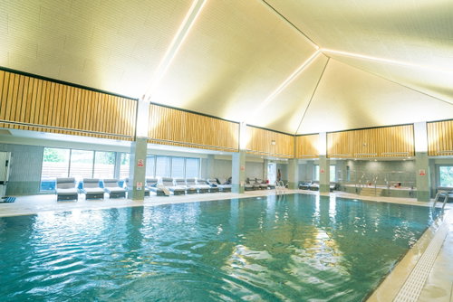 A calm outdoor pool beside a spa garden